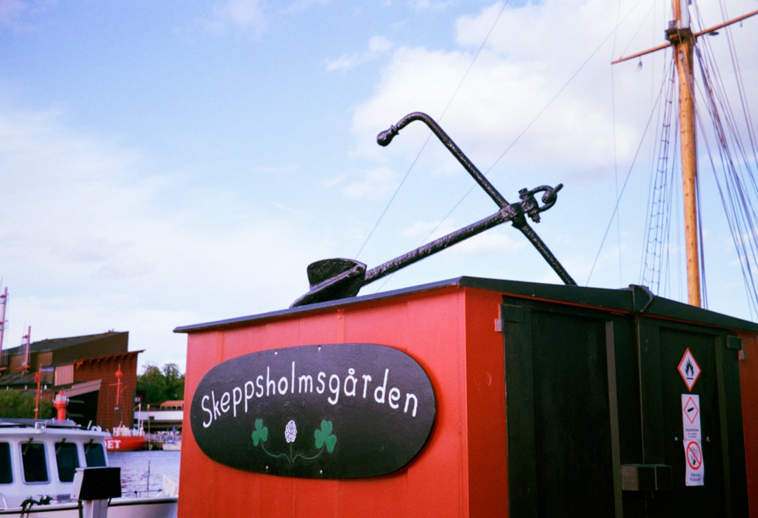An anchor sits atop a building with a sign.