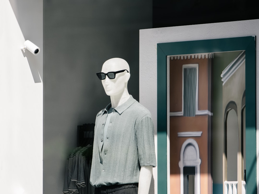 a white mannequin wearing sunglasses and a gray shirt